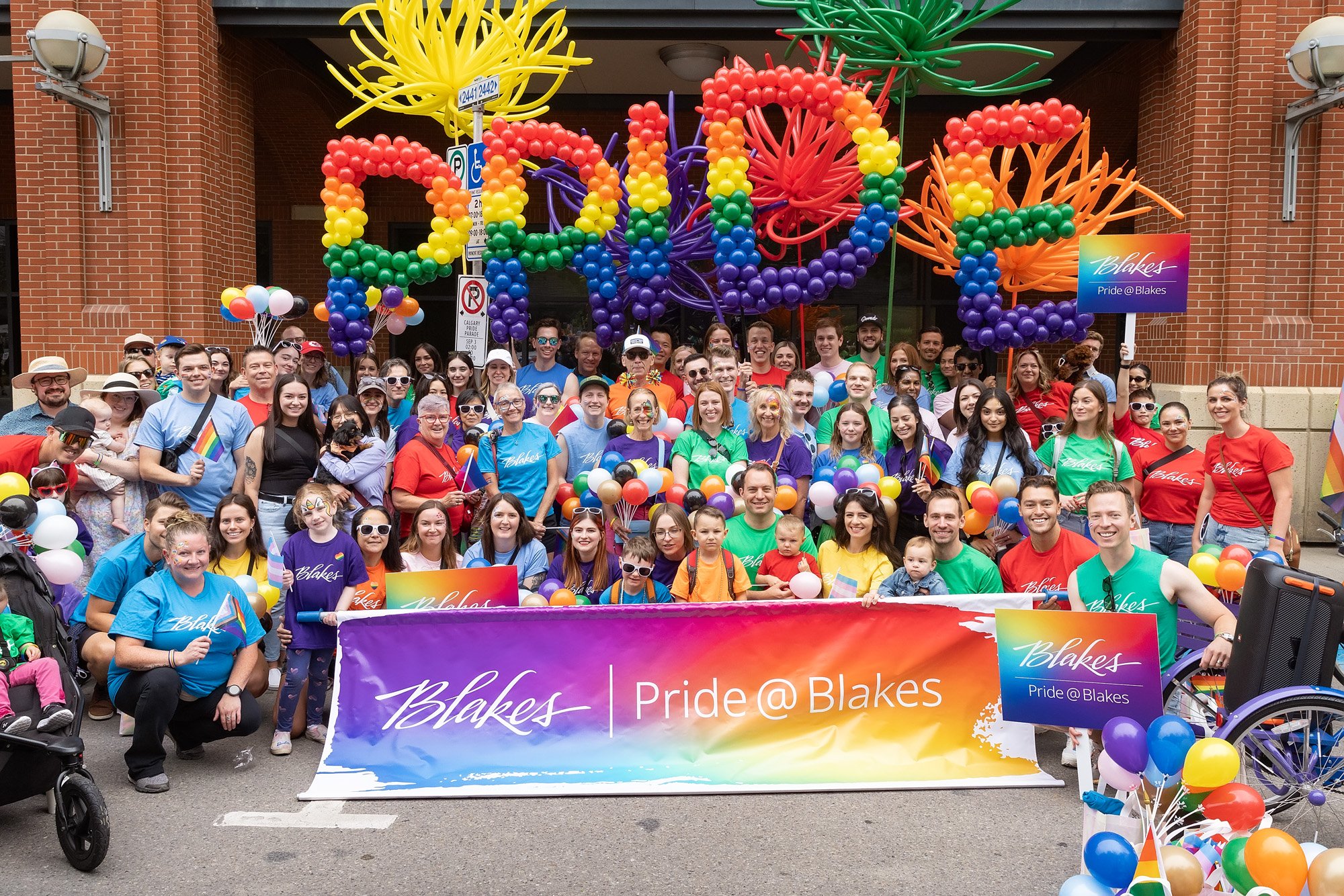 Blakes pride members gathered for a group shot with colourful balloons for the pride parade in Calgary.